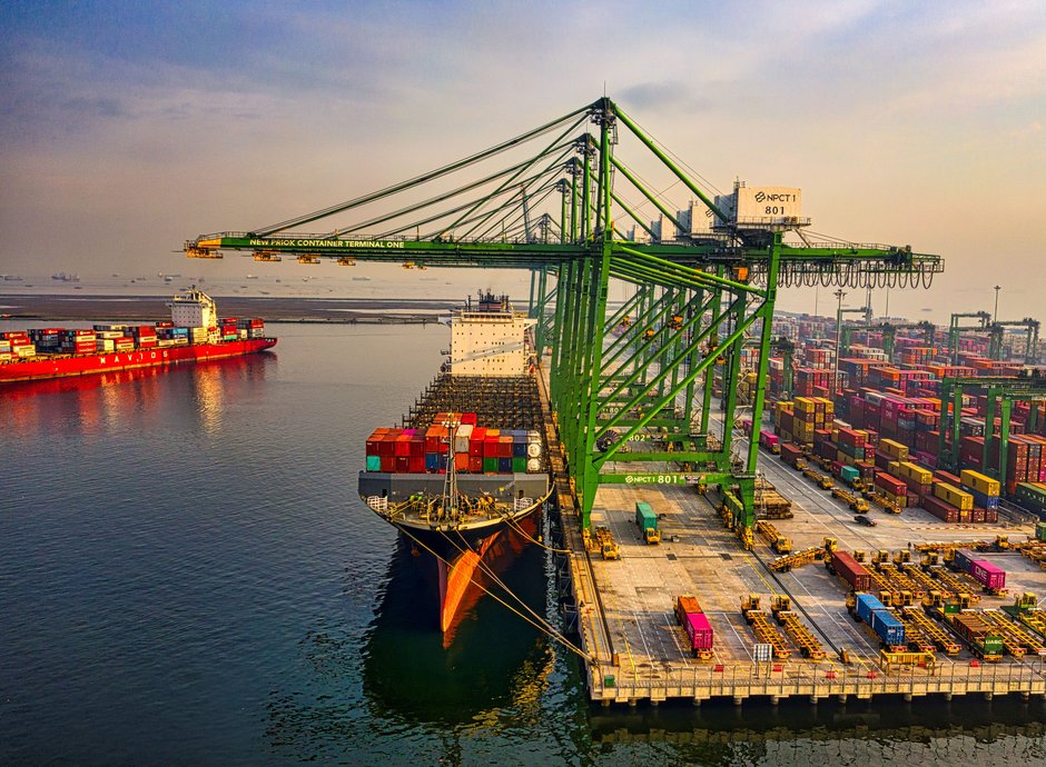 Terminal portuaria de contenedores con buque amarrado y grúas, operación de logística y transporte de carga